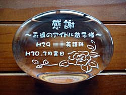 「感謝 ○○先生、学校名」を彫刻した、卒業生から担任の先生へのプレゼント用のガラス製ペーパーウェイト