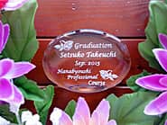 「Graduation、卒業生の名前、学校名」を彫刻した、卒業記念品のガラス製ペーパーウェイト
