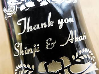 両親へ贈呈するシャンパンのボトル側面に彫刻した、「感謝を込めたメッセージ（Thank you）と新郎新婦の名前（Shinji & Akari）」のクローズアップ画像