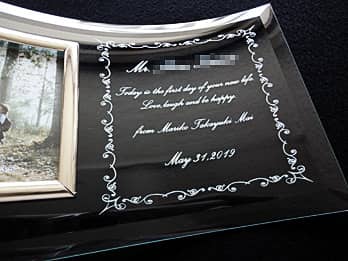 「退職する方の名前、はなむけの言葉、贈り主の名前、日付」を彫刻した、定年退職のお祝い品用のガラス製フォトスタンド