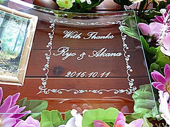 「With thanks、新郎と新婦の名前、結婚式の日付」を彫刻した、披露宴で両親へ贈呈するガラス製写真立て