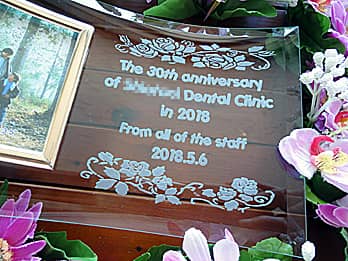 「The 30th anniversary of ○○ dental clinic」を彫刻した、歯科医院の周年祝い用のガラス製写真立て
