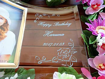 「Happy birthday、贈る相手の名前と誕生日の日付」を彫刻した、誕生日プレゼント用のガラス製写真立て
