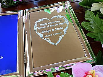「Happy anniversary、旦那様と奥さまの名前、結婚記念日の日付」を彫刻した、結婚記念日の贈り物用のブック型写真立て