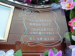 「○○おばあちゃん 米寿おめでとう、○○より」を彫刻した、おばあちゃんへの米寿祝い用のガラス製写真立て