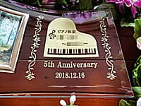 「ロゴマーク、5th anniversary、日付」を彫刻した、ピアノ教室の周年祝い用の写真立て