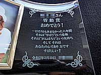 「○○さん 皆勤賞おめでとう」を彫刻した、小学校の皆勤賞の記念品用のフォトスタンド