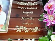 「ご結婚おめでとうございます、新郎と新婦の名前、挙式日」を彫刻した、結婚祝い用のガラス製フォトスタンド