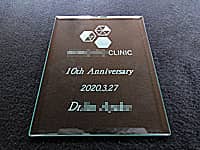 「クリニックのロゴマーク」と「10th anniversary 2020.3.27 Dr.○○」を彫刻した、クリニックの周年祝い用のガラス盾