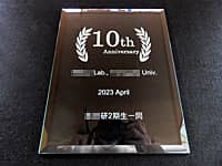 「10th anniversary ○○Lab.○○Univ. 、日付と贈り主の名前」を彫刻した、大学の研究室の10周年祝い用のガラス盾