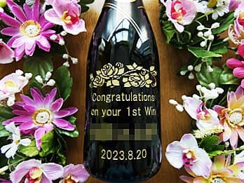 「Congratulations on your 1st win、優勝者の名前、優勝した日付」をボトル側面に彫刻した、優勝記念用のシャンパン