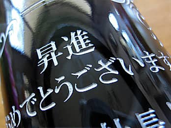 昇進祝い用のワインボトル側面に彫刻した、「お祝いメッセージ」のクローズアップ画像
