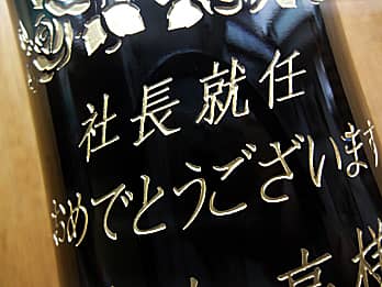 社長就任祝い用のワインボトル側面に彫刻した、「お祝いメッセージ」のクローズアップ画像