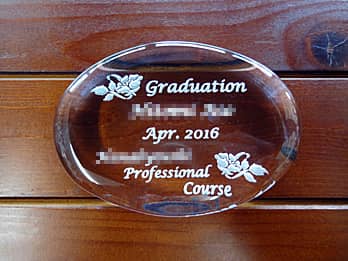 「Graduation、卒業生の名前、学校名」を彫刻した、卒業記念品用のガラス製ペーパーウェイト