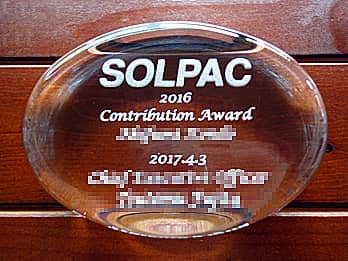 「会社名、2016 contribution award、○○殿」を彫刻した、賞品用のガラス製ペーパーウェイト