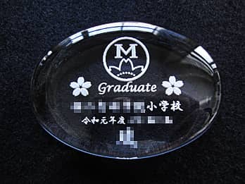 校章を彫刻した、卒業記念品用のガラス製ペーパーウェイト