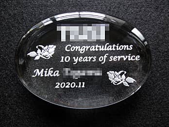 「Congratulations 10years of service、永年勤続者の名前、表彰日の日付」を彫刻した、永年勤続表彰用のガラス製ペーパーウェイト