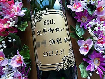 「60th 定年御祝い ○○様、退職する日付」を一升瓶の側面に彫刻した、定年退職祝い用の日本酒