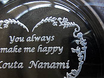 バレンタインデーのプレゼント用のガラス製灰皿の底面に彫刻した、「メッセージ、カップルの名前」のクローズアップ画像