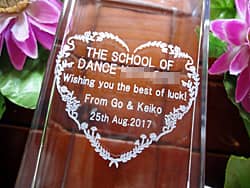 「ダンススクールの名前、Wishing you the best of luck」を側面に彫刻した、ダンススクールの開業祝い用のガラス花瓶