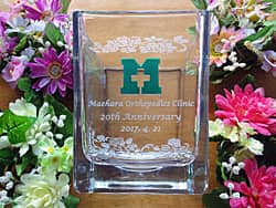 「20th anniversary、クリニックのマーク」を側面に彫刻した、クリニックの周年祝い用のガラス花瓶