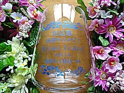 「祝退職 感謝を込めて、名前、○○一同」を側面に彫刻した、定年退職のお祝い品用のガラス花器