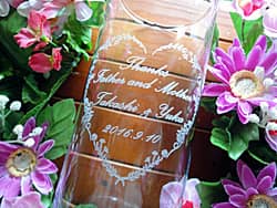 「Thanks Father & Mother、新郎と新婦の名前、結婚式の日付」を側面に彫刻した、両親への贈り物用のフラワーベース