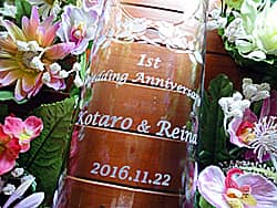 「1st wedding anniversary、旦那様と奥さまの名前、結婚記念日の日付」を側面に彫刻した、奥さまへの結婚記念日の贈り物用のガラス花器