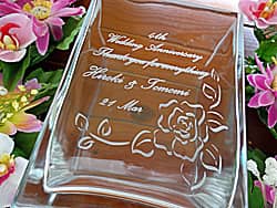 奥さまの名前と感謝を込めたメッセージを側面に彫刻した、奥さまへの結婚記念日のプレゼント用のガラス花器