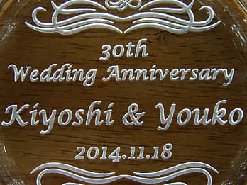結婚記念日のプレゼント用のガラス製灰皿の底面に彫刻した、「30th Wedding Anniversary、旦那様と奥さまの名前、結婚記念日の日付」のクローズアップ画像
