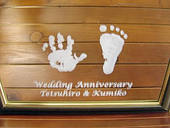 「Wedding anniversary、奥さまと旦那様の名前、お子様の手形と足形」を表面に彫刻した、結婚記念日祝い用の鏡