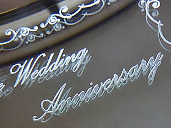 結婚記念日祝い用のブック型写真立ての鏡部分に彫刻した「Wedding Anniversary」のクローズアップ画像