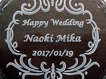 結婚祝い用のガラス製灰皿の底面に彫刻した、「Happy Wedding、新郎と新婦の名前、結婚式の日付」のクローズアップ画像