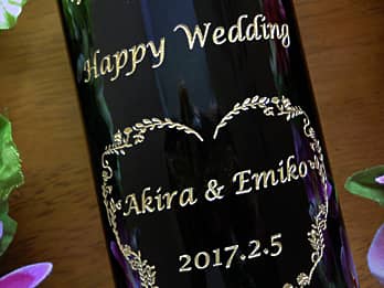結婚祝い用のワインボトル側面に彫刻した、「Happy Wedding、新郎と新婦の名前、結婚式の日付」のクローズアップ画像
