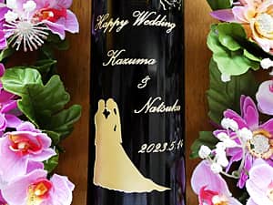メッセージと、新郎と新婦のシルエットのイラストをボトル側面に彫刻した結婚祝い用のワイン
