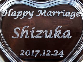 結婚祝い用のガラス製小物入れの蓋に彫刻した、「Happy Marriage、新婦の名前、結婚式の日付」のクローズアップ画像