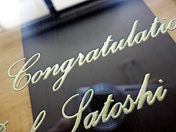 結婚祝い用の掛け時計の前面ガラスに彫刻したお祝いメッセージを、ゴールドに着色加工した画像