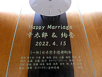 「Happy Marriage、新郎と新婦の名前、結婚式の日付、贈り主の名前」を前面ガラスに彫刻した、結婚祝い用の掛け時計