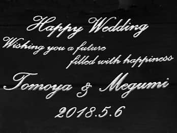結婚祝い用のガラス製写真立てに彫刻した、「お祝いメッセージ、新郎と新婦の名前、日付」のクローズアップ画像